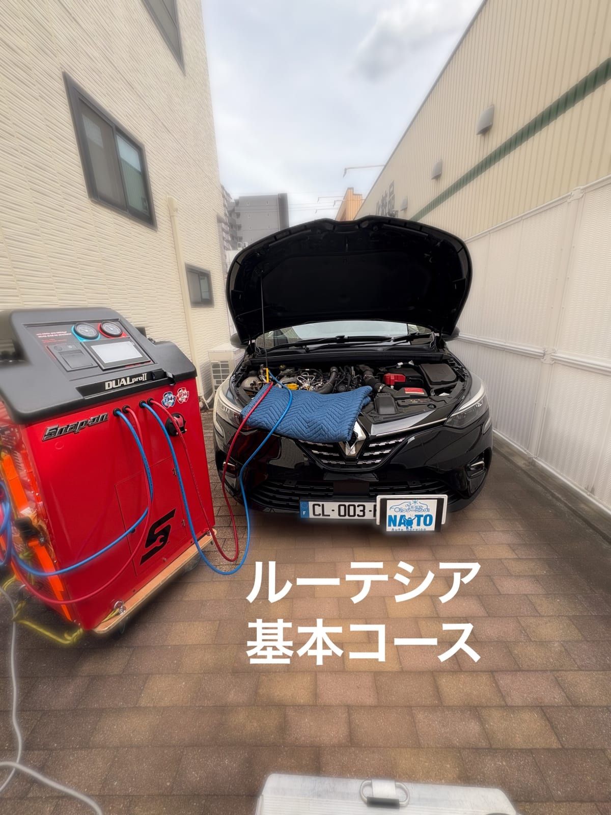 エンジンルームに機械のホースをつないだ作業中の様子